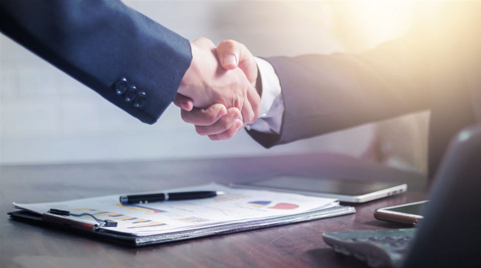 Professional handshake over analysis documents